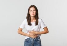 woman having stomach ache bending and with hands on belly discomfort from menstrual cramps 1680613458 1680614081 1698721722 1698721844